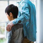 父親に支えられる男の子