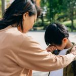 泣く小学生男子を慰める母親