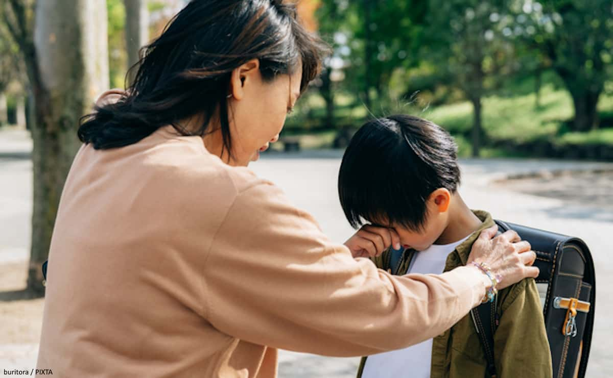 泣く小学生男子を慰める母親