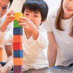 積み木で遊ぶ男の子と父母