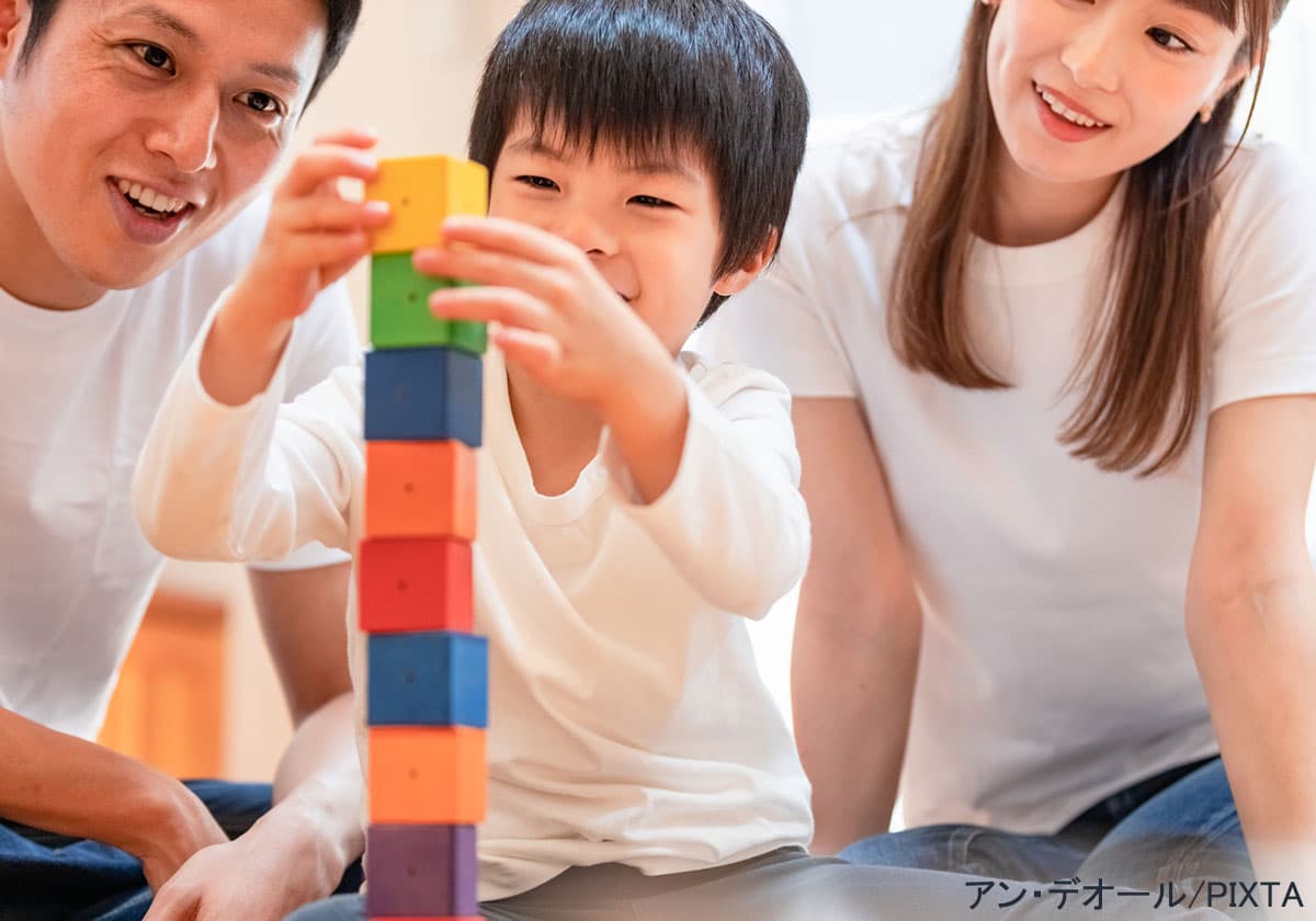 積み木で遊ぶ男の子と父母