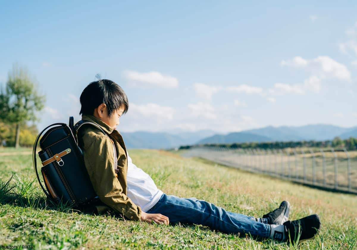 草原に座る男の子