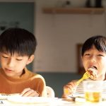 食事をする2人の小学生の男の子