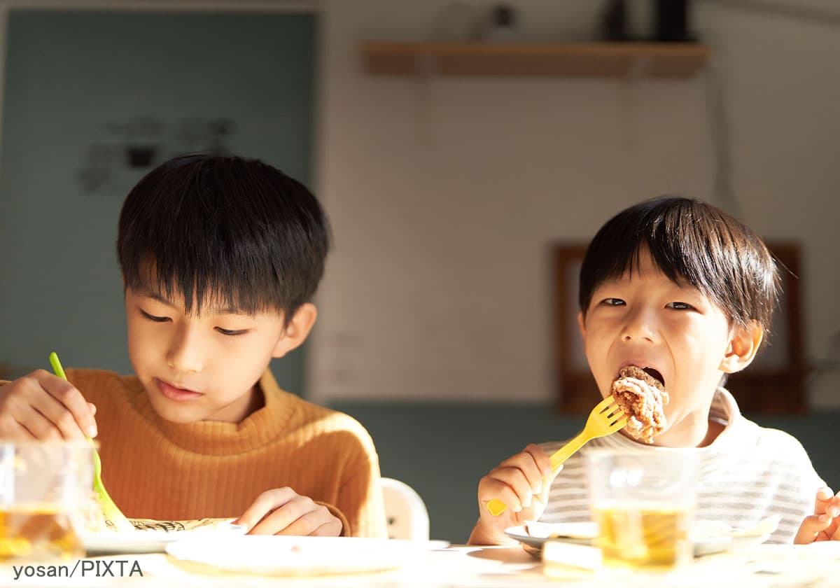 食事をする2人の小学生の男の子