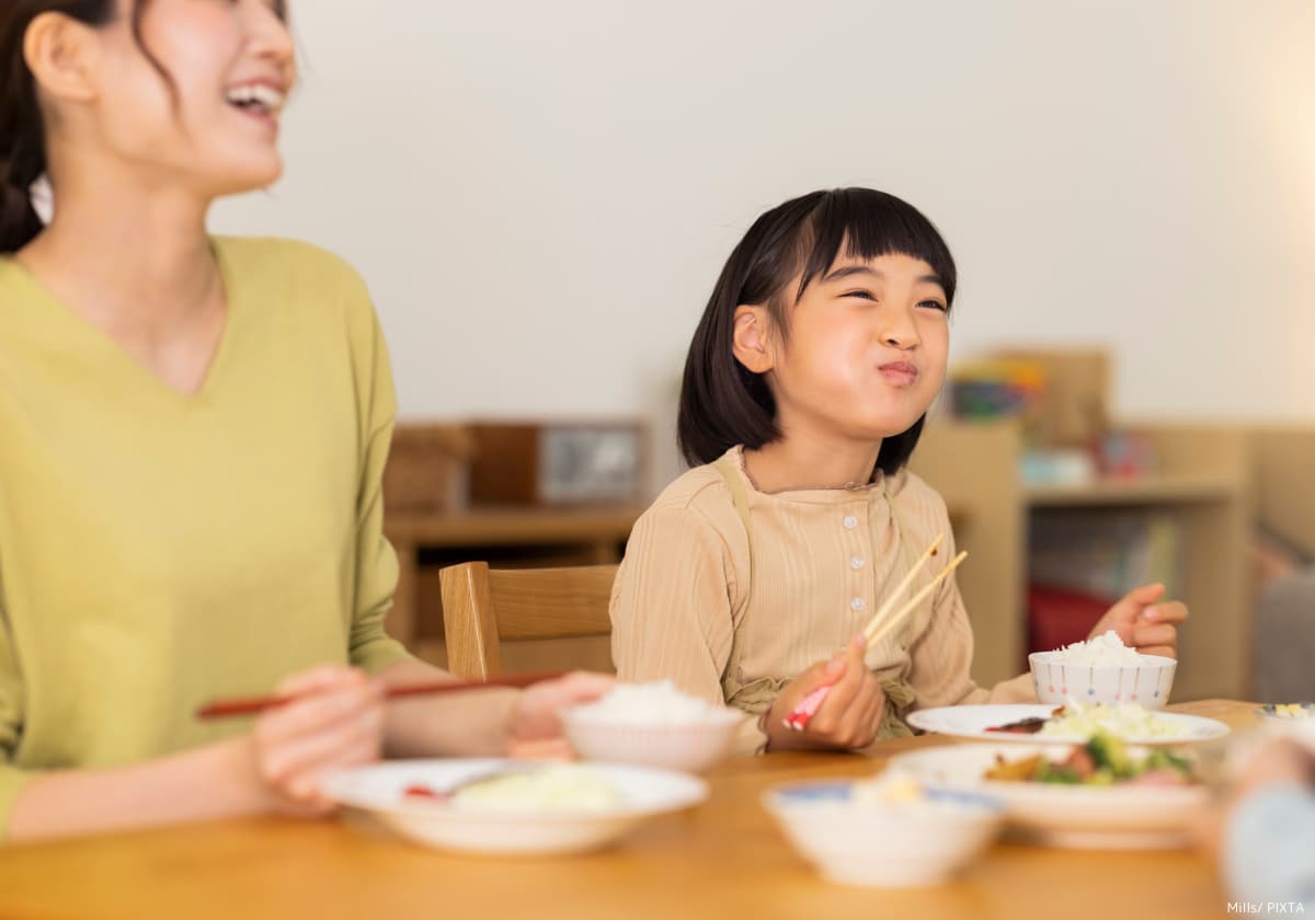 家族と夕飯を食べる小学生の女の子