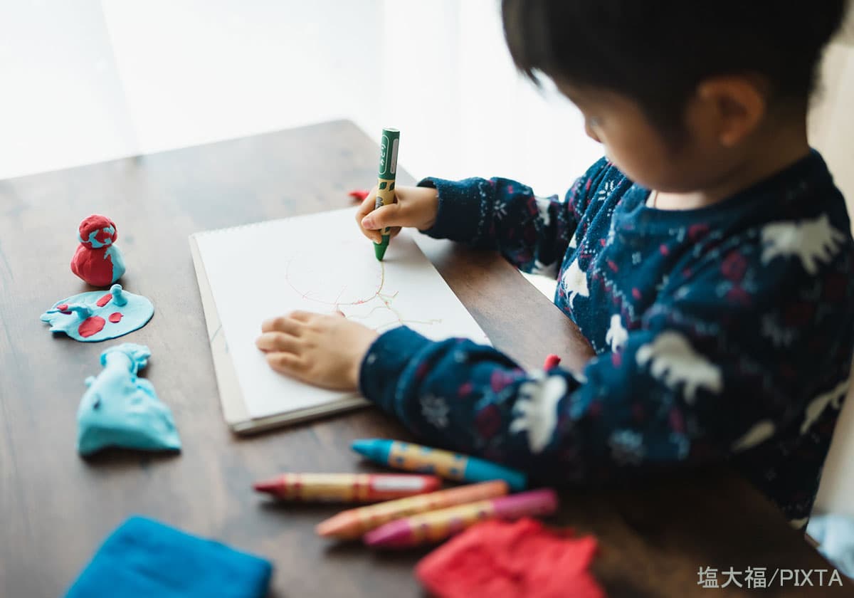 クレヨンでおえかきする子