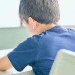 勉強をする小学生の子の背中