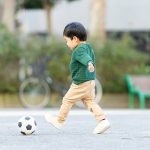 サッカーボールを追いかける3歳の子