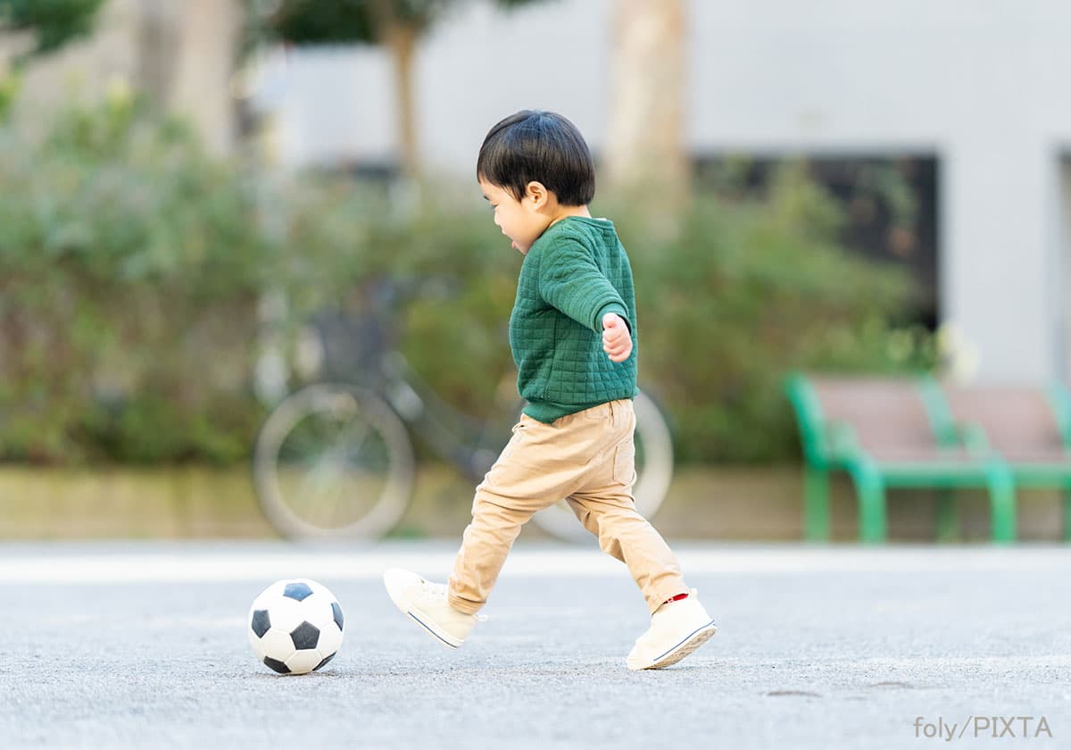 サッカーボールを追いかける3歳の子