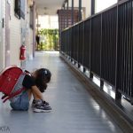 廊下で座り込む小学生の女の子